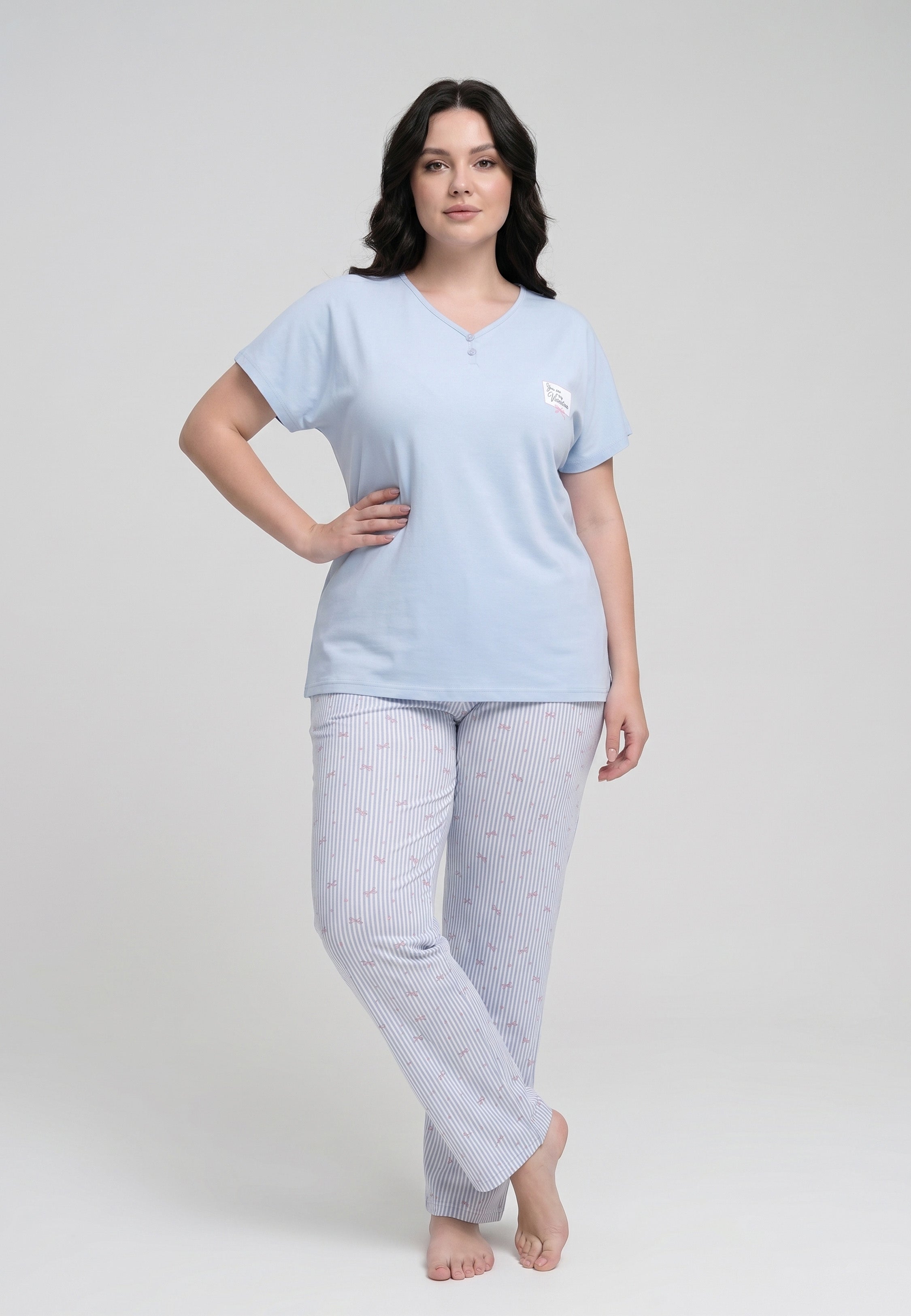 Femme portant un pyjama grande taille top col V boutonné manches courtes uni bleu ciel badge brodé et pantalon droit rayé fleuri bleu ciel et blanc Rosabella Lina