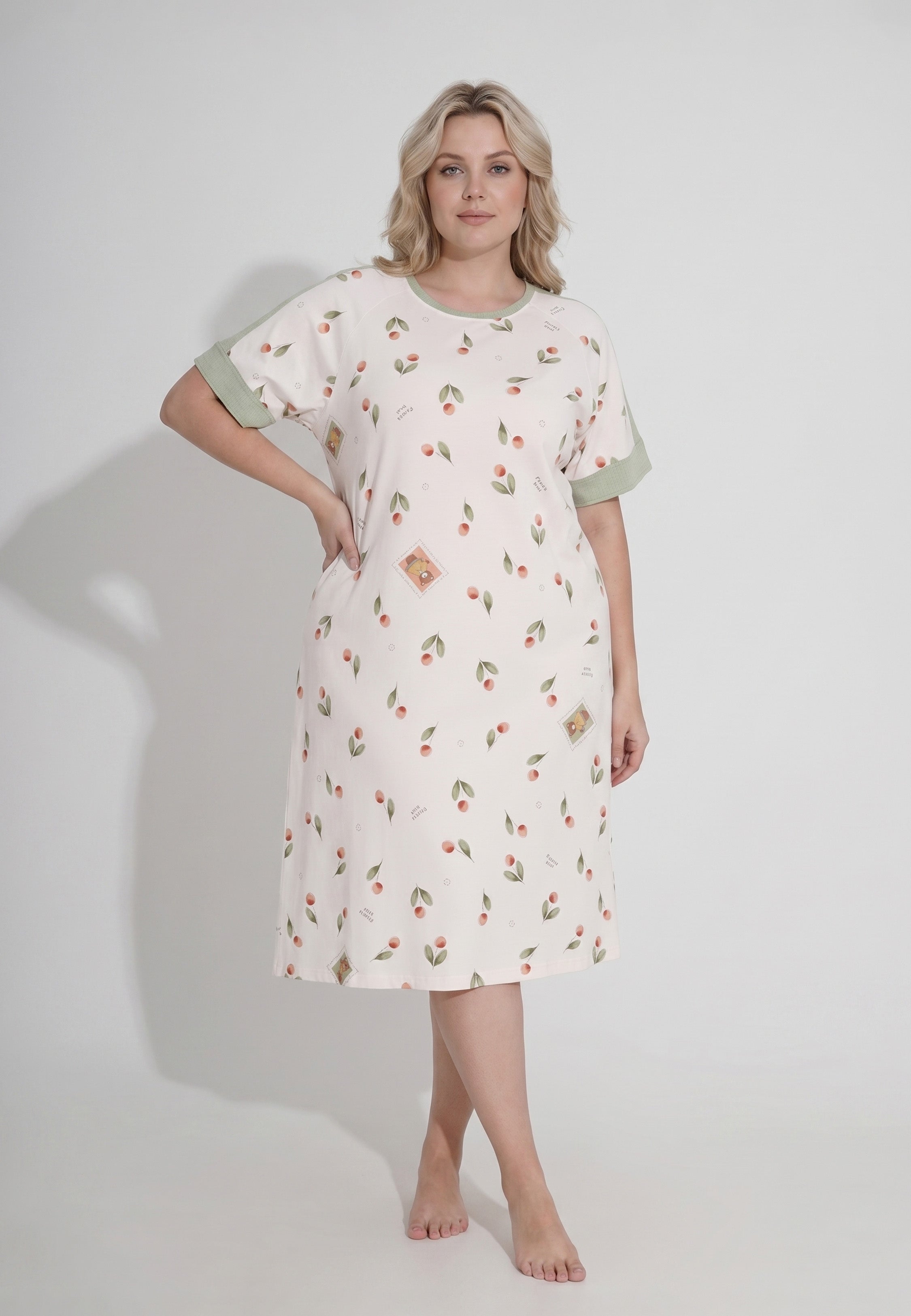 Femme portant une robe de nuit midi col rond manches courtes imprimé cerises et pêches aquarelle fond crème parements contrastants kaki Rosabella Douceur Cerise