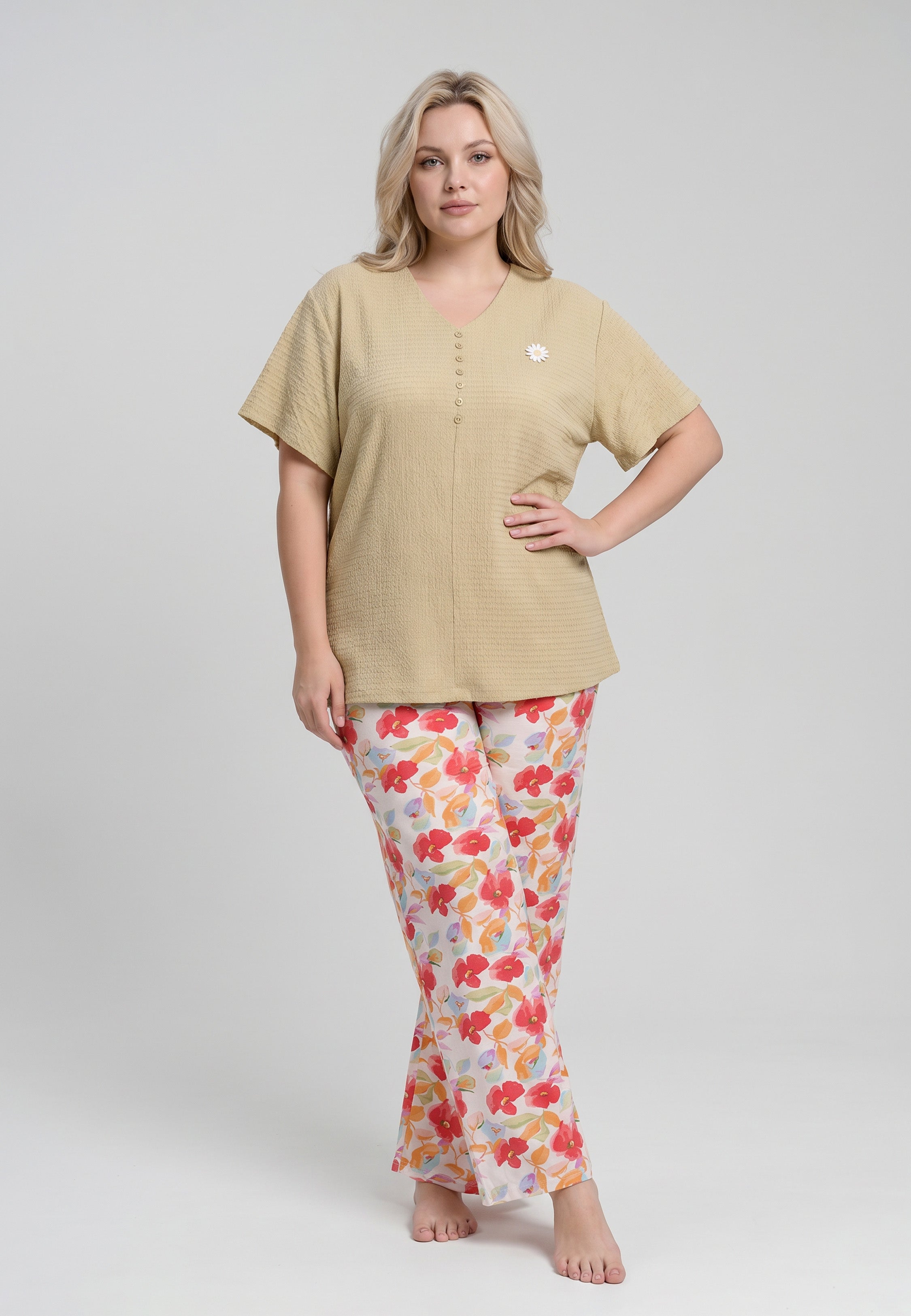 Femme portant un pyjama top col V boutonné manches courtes texturé uni moutarde foncé badge marguerite brodé et pantalon large grand imprimé fleuri aquarelle multicolore fond blanc Rosabella Rosy Mood