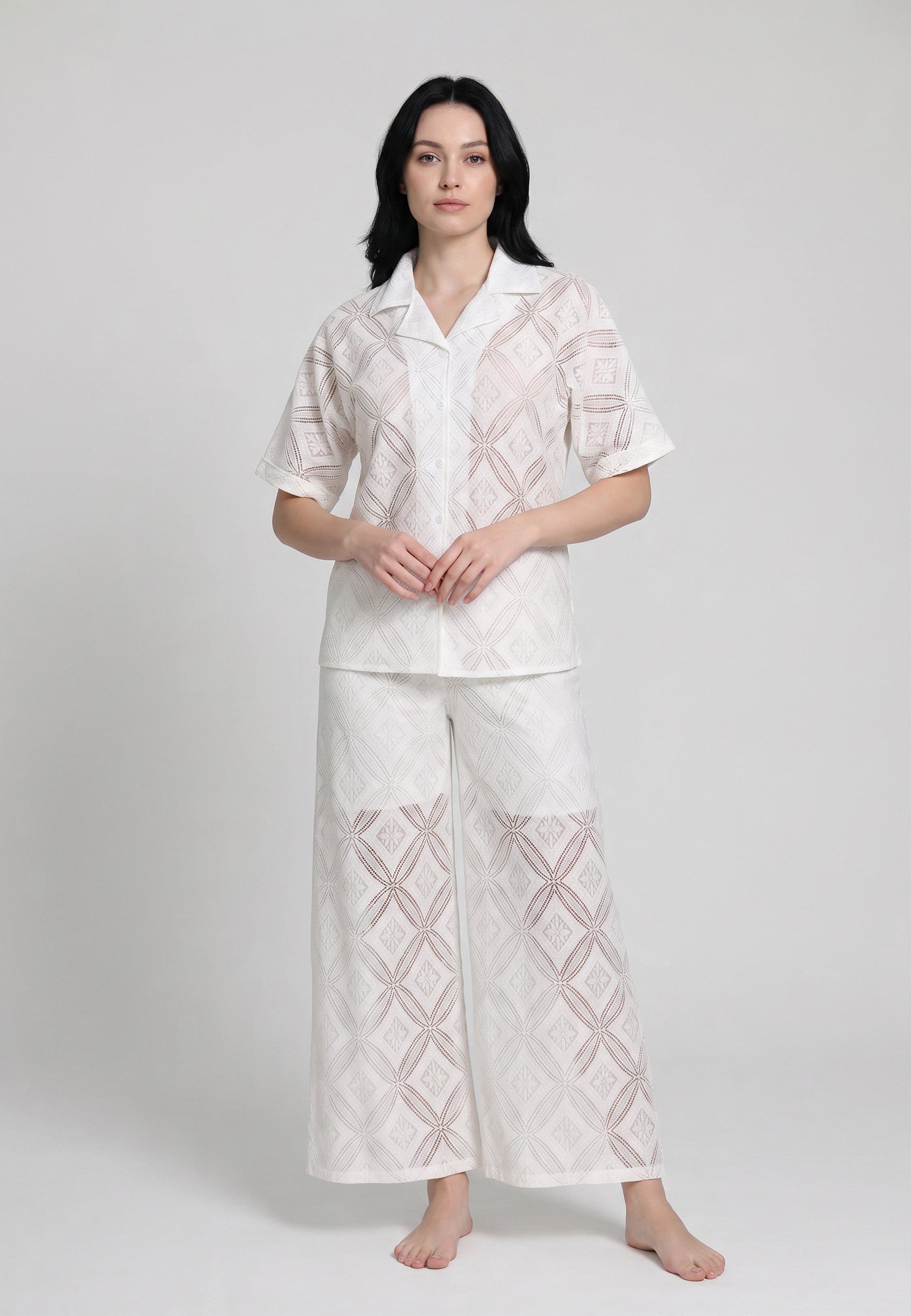 Femme portant un ensemble chemise camp boutonnée manches courtes et pantalon large broderie anglaise ajourée géométrique ivoire Rosabella