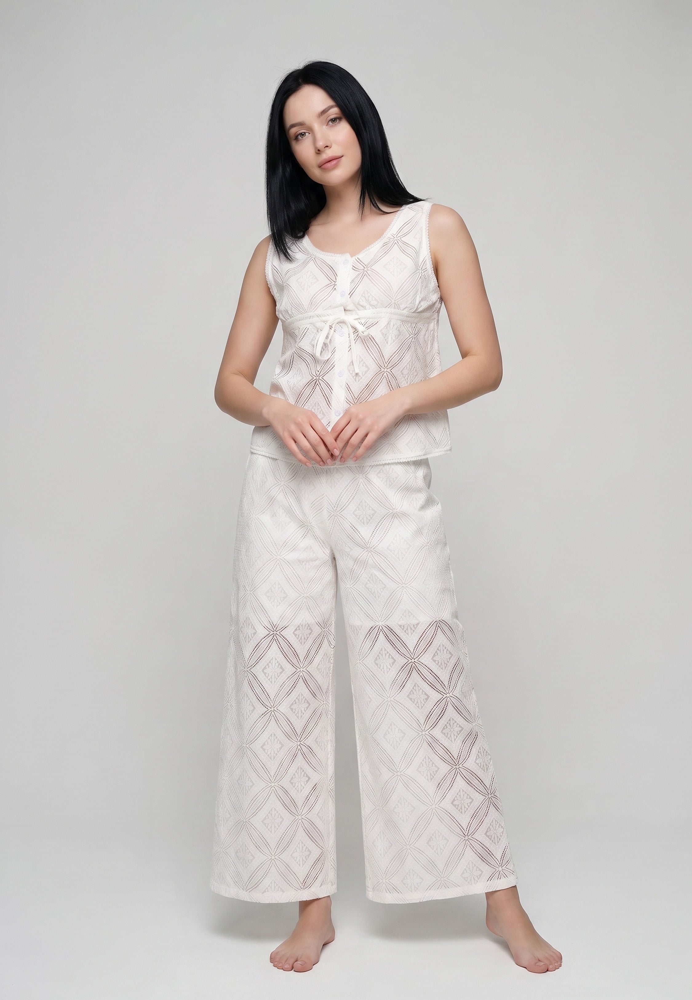 Femme portant un ensemble débardeur col rond noué broderie anglaise ajourée géométrique ivoire et pantalon large assorti Rosabella