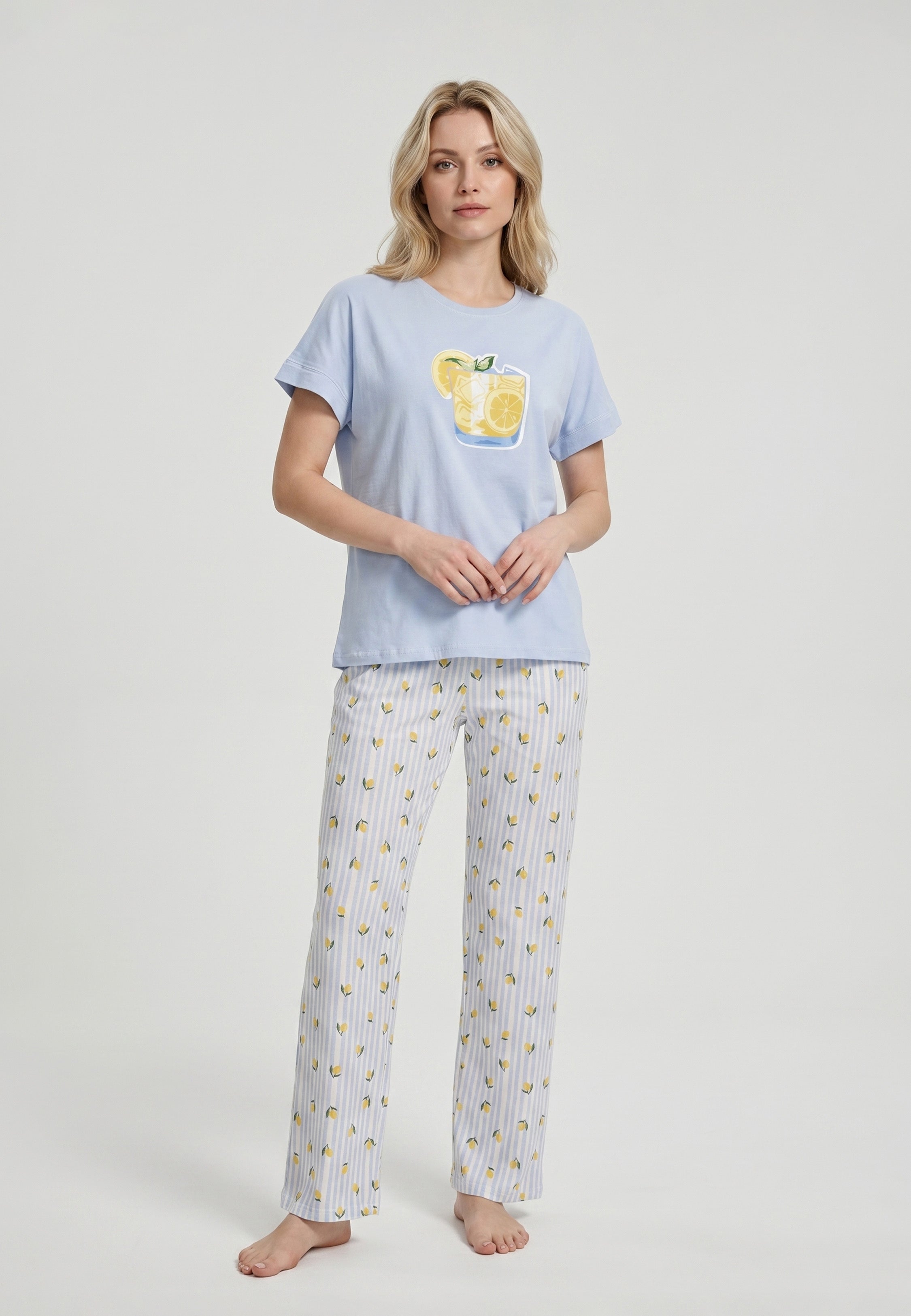 Femme portant un pyjama t-shirt manches courtes bleu ciel grand badge citronnade et pantalon rayé bleu ciel blanc imprimé petits citrons Rosabella