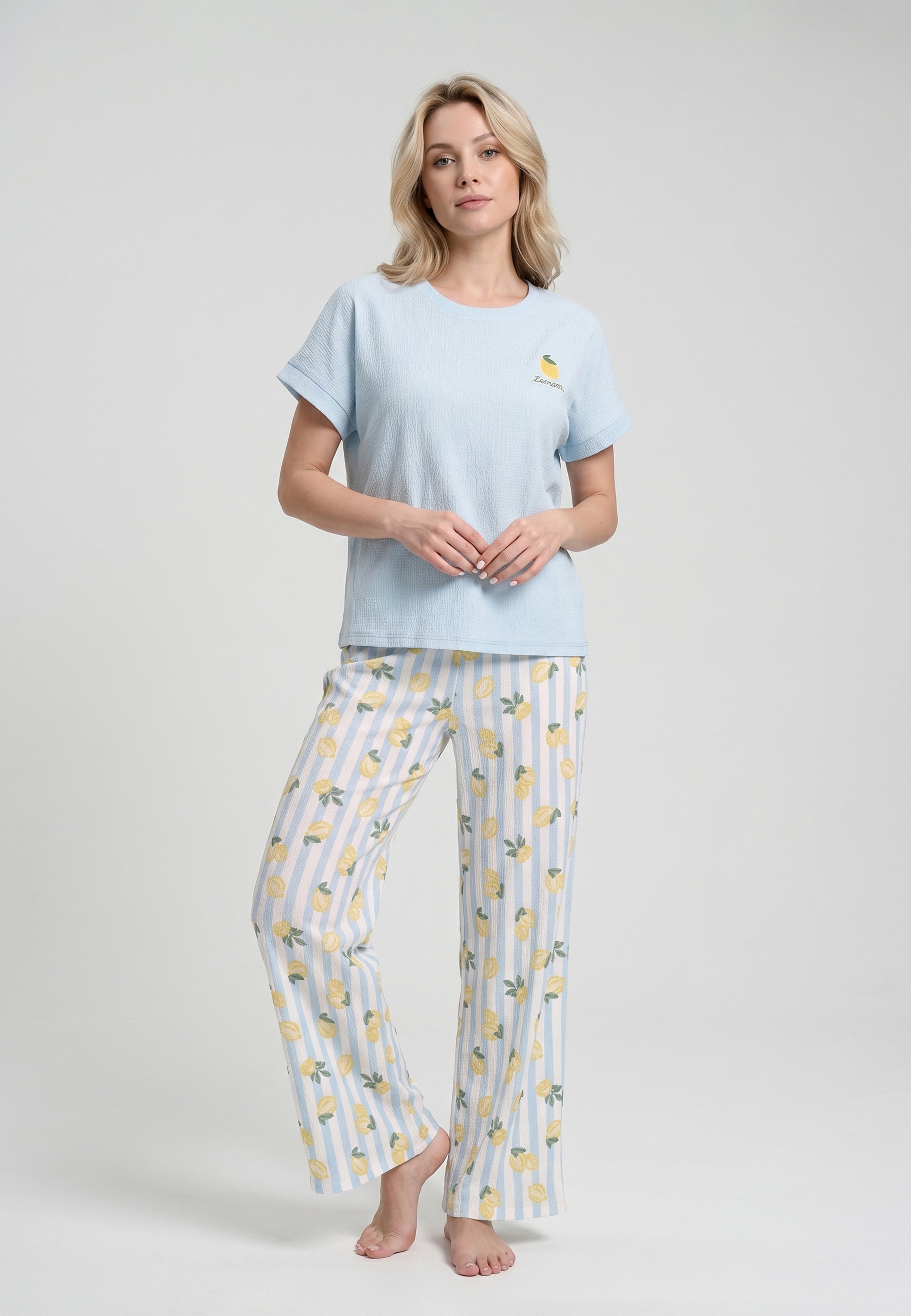 Femme portant un ensemble loungewear top col rond uni bleu ciel badge brodé citron et pantalon large rayures bleu ciel blanc imprimé citrons jaunes Rosabella