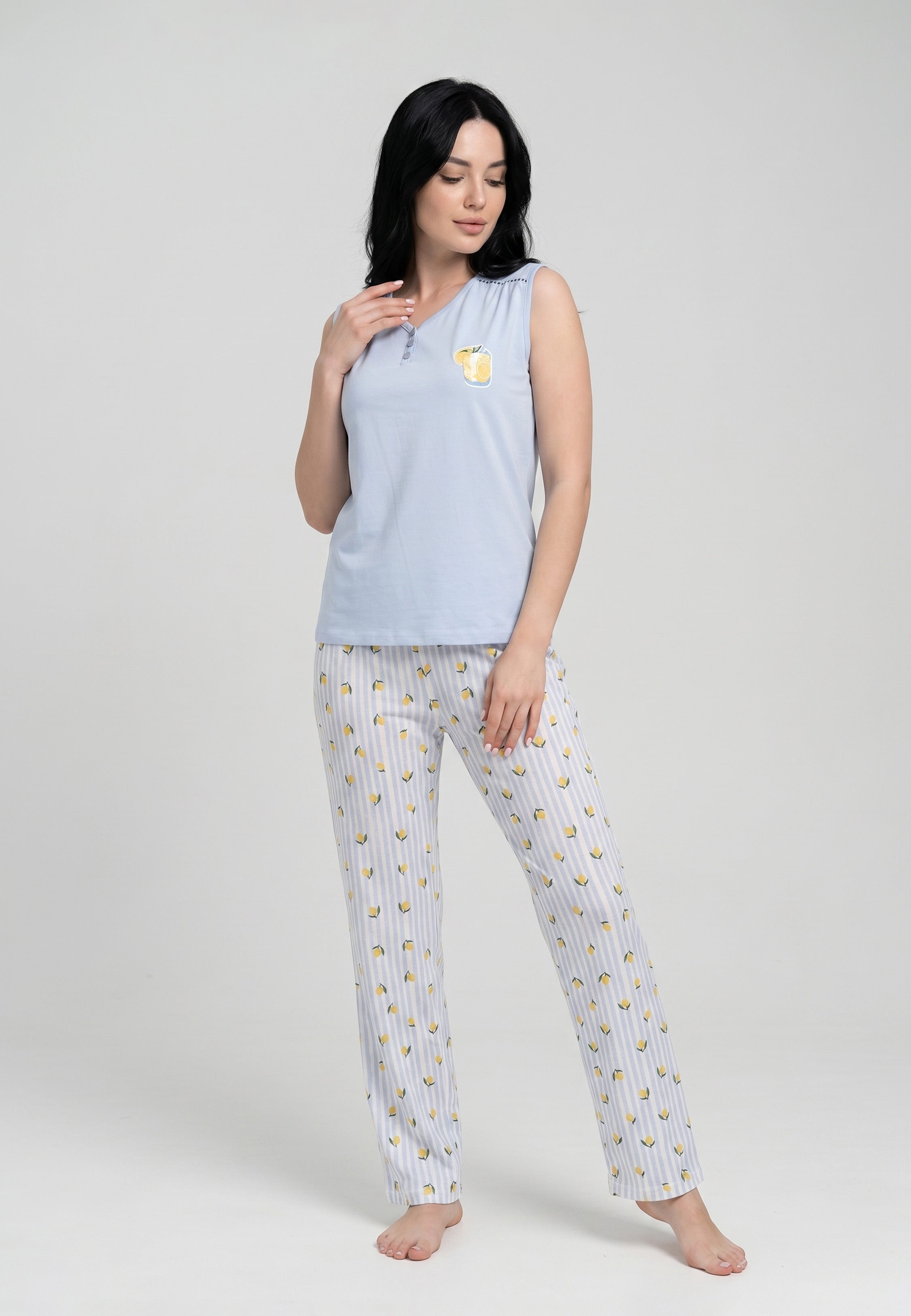 Femme portant un pyjama débardeur sans manches col V boutonné bleu ciel badge citronnade et pantalon rayé bleu ciel blanc imprimé petits citrons Rosabella