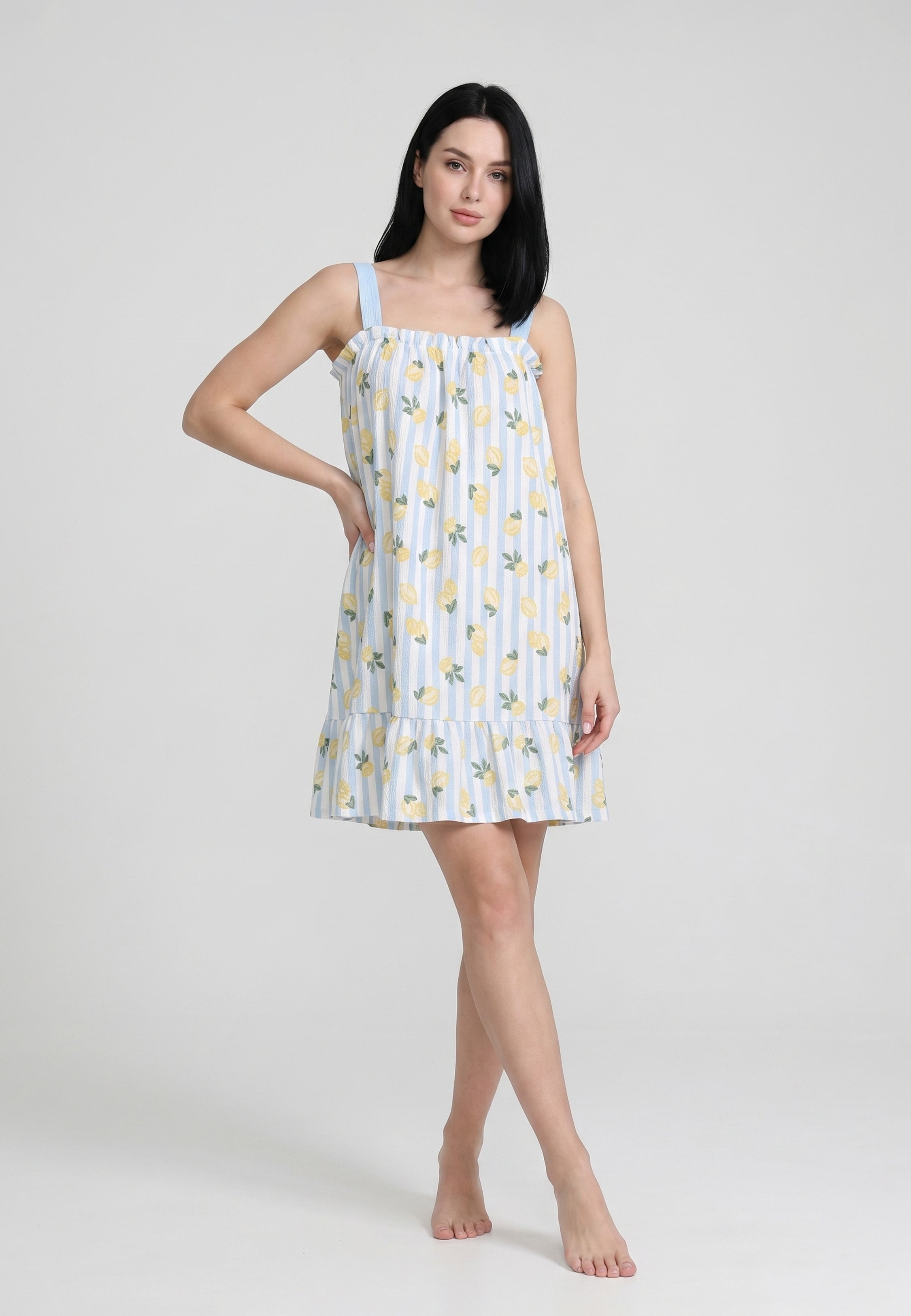 Femme portant une robe courte sans manches buste froncé imprimée citrons jaunes fond rayé bleu ciel et blanc bretelles larges contrastantes bleu ciel volant bas Rosabella