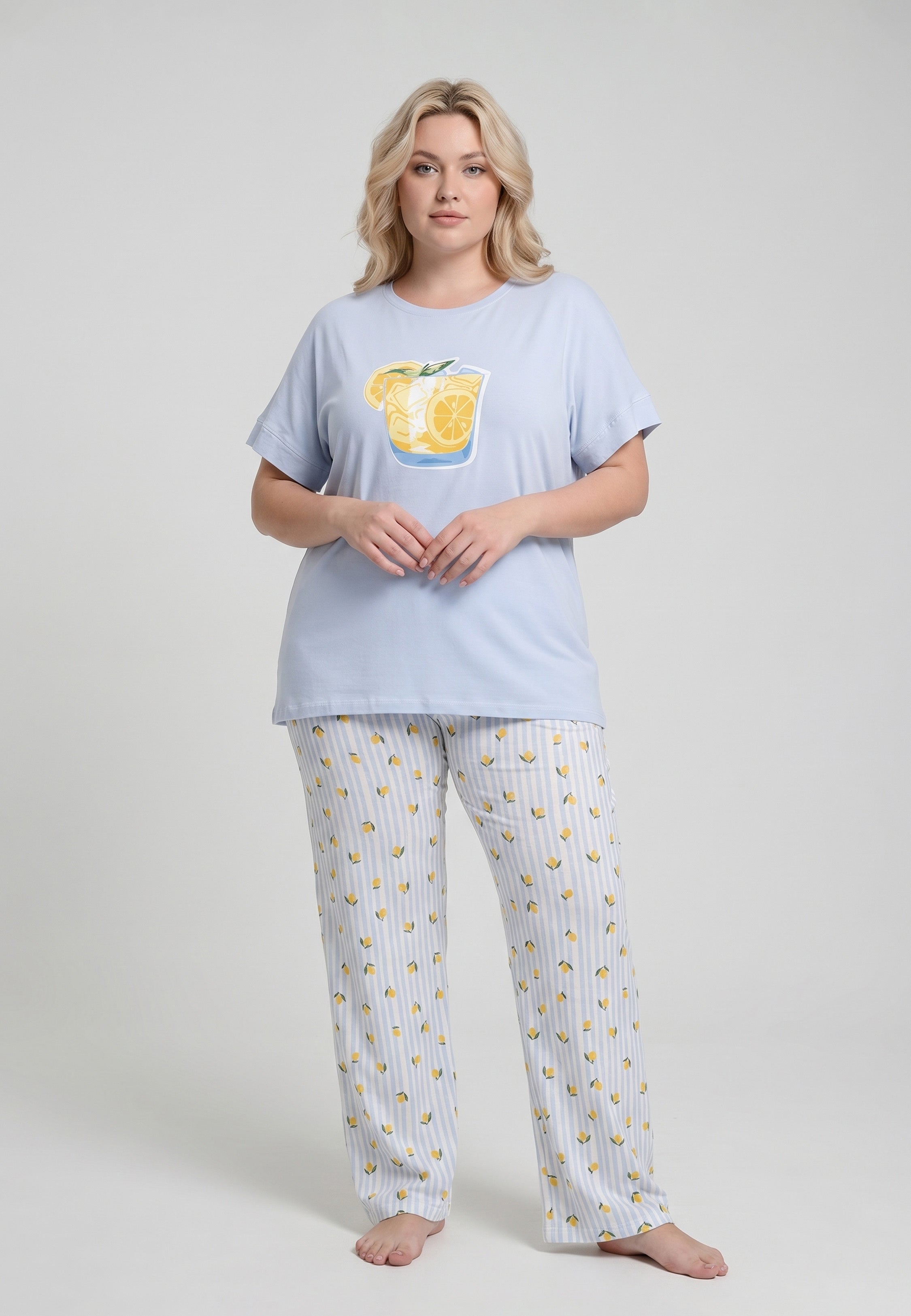 Femme portant un pyjama grande taille t-shirt bleu ciel grand badge citronnade et pantalon rayé bleu ciel blanc imprimé petits citrons Rosabella