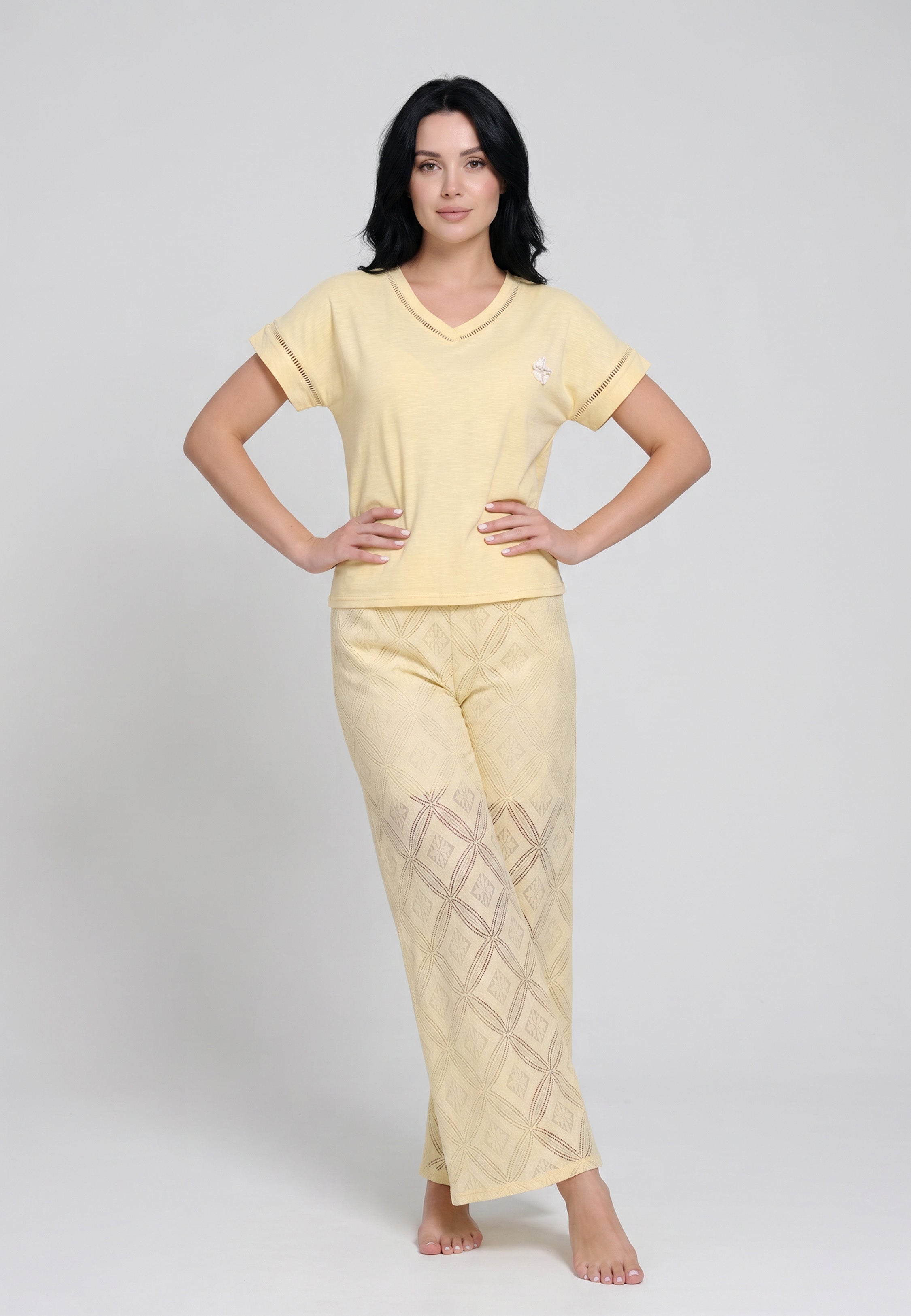 Femme portant un ensemble top col V oversize liseré ajouré broderie Winnie et pantalon large broderie anglaise géométrique jaune beurre Rosabella
