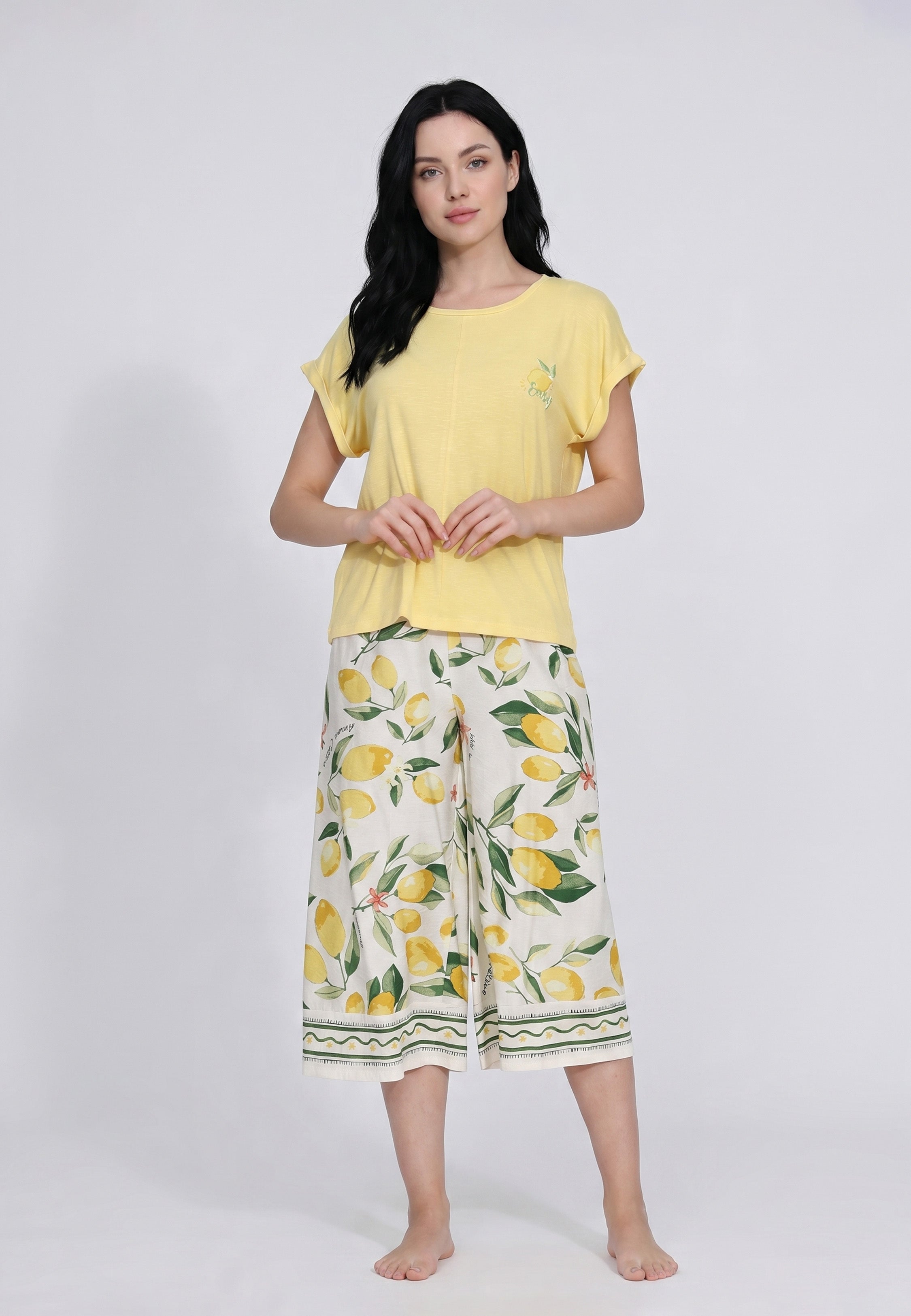 Femme portant un ensemble loungewear t-shirt col rond jaune citron badge et pantacourt large crème imprimé grands citrons aquarelle bordure géométrique Rosabella