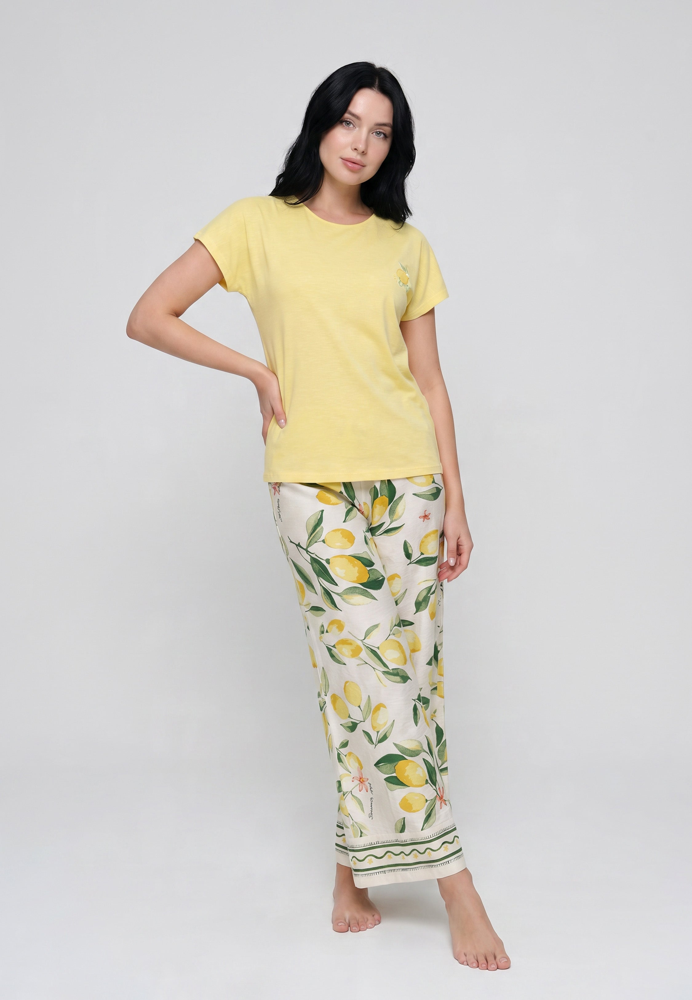 Femme portant un ensemble loungewear t-shirt col rond jaune citron badge et pantalon large palazzo crème imprimé grands citrons aquarelle bordure géométrique Rosabella