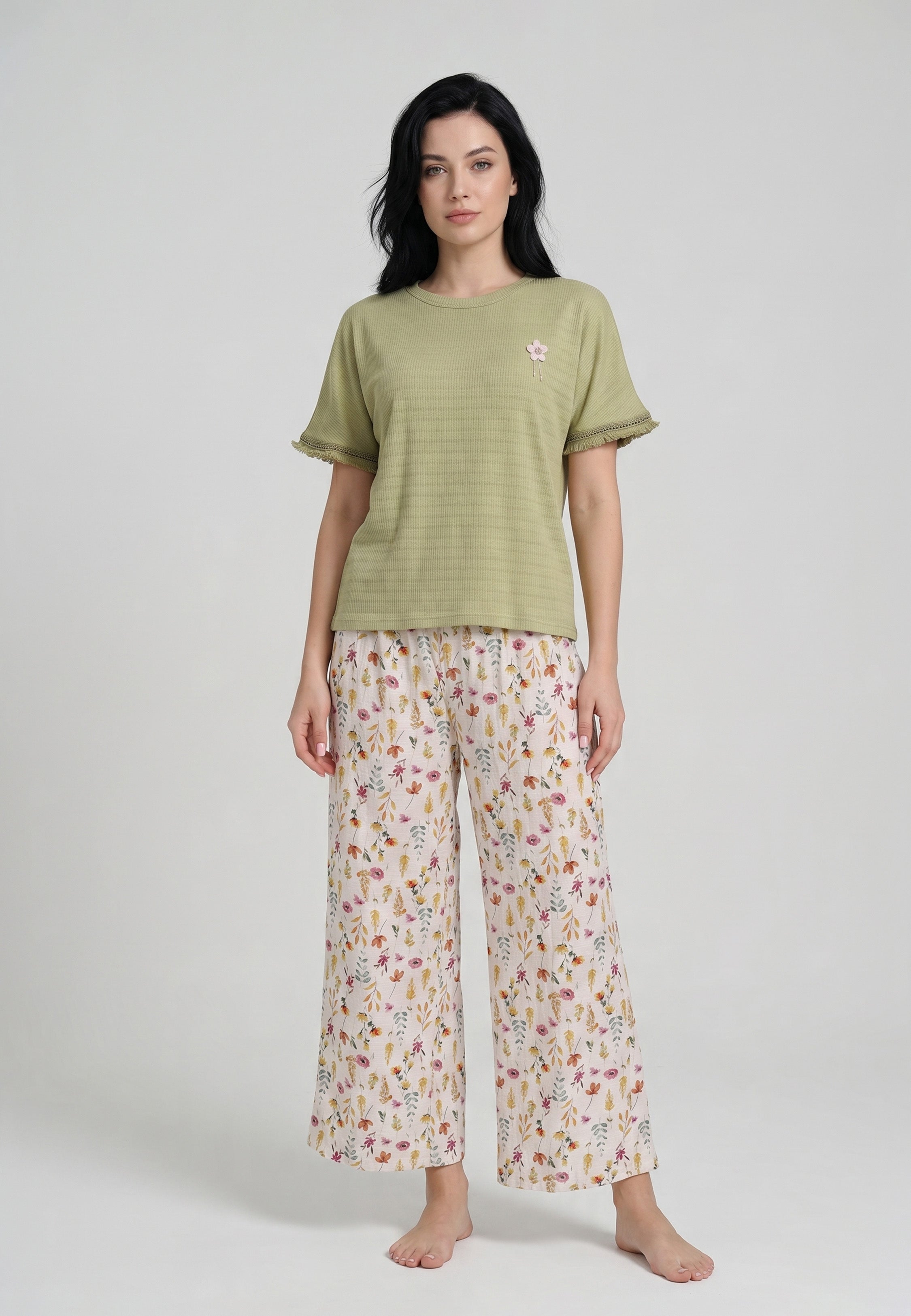 Femme portant un ensemble loungewear top col rond côtelé kaki dentelle ajourée badge floral et pantalon large crème imprimé petites fleurs sauvages multicolores Rosabella
