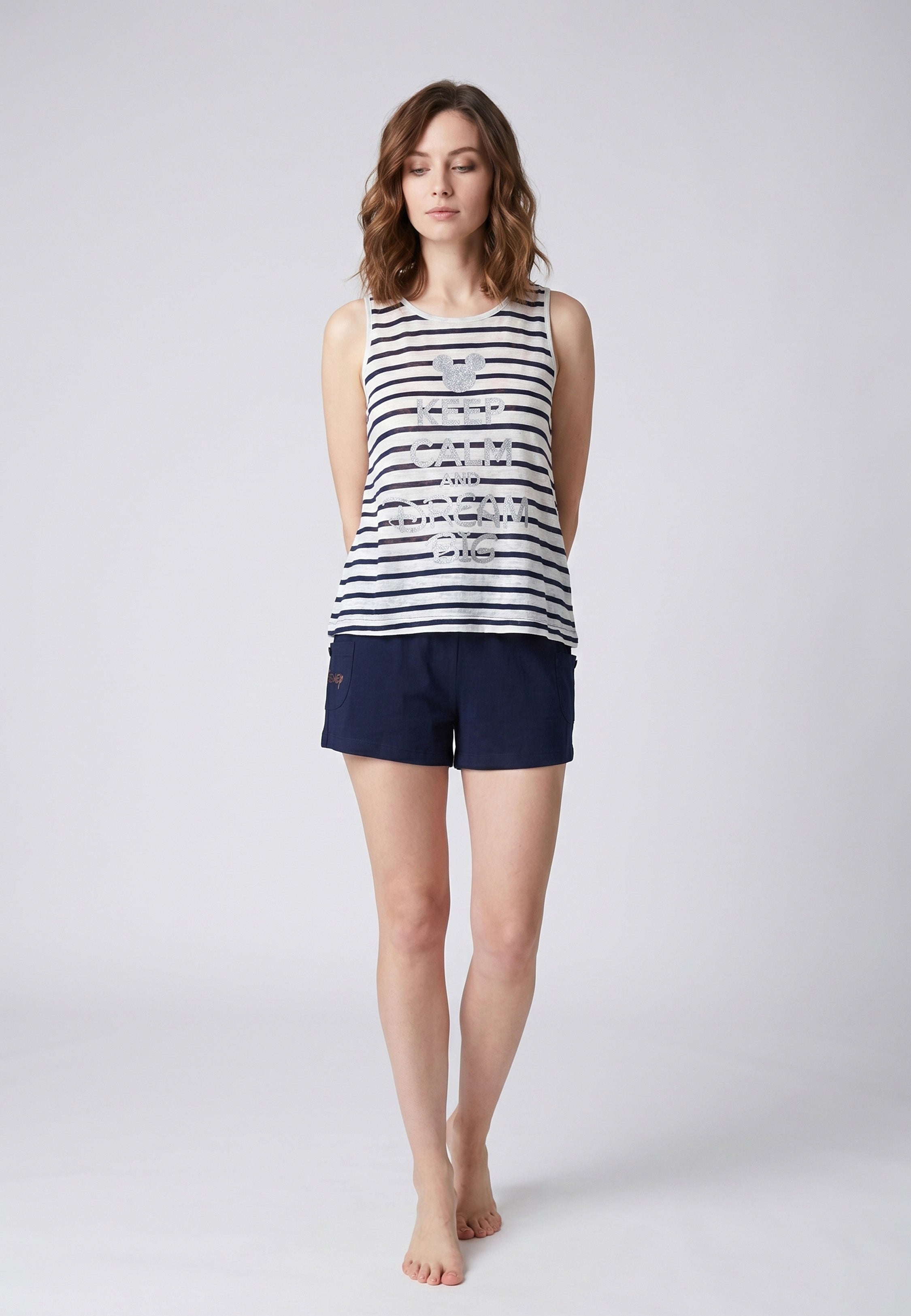 Femme portant un pyjama deux pièces débardeur rayé marine avec inscription pailletée Keep Calm and Dream Big Mickey et short uni bleu marine