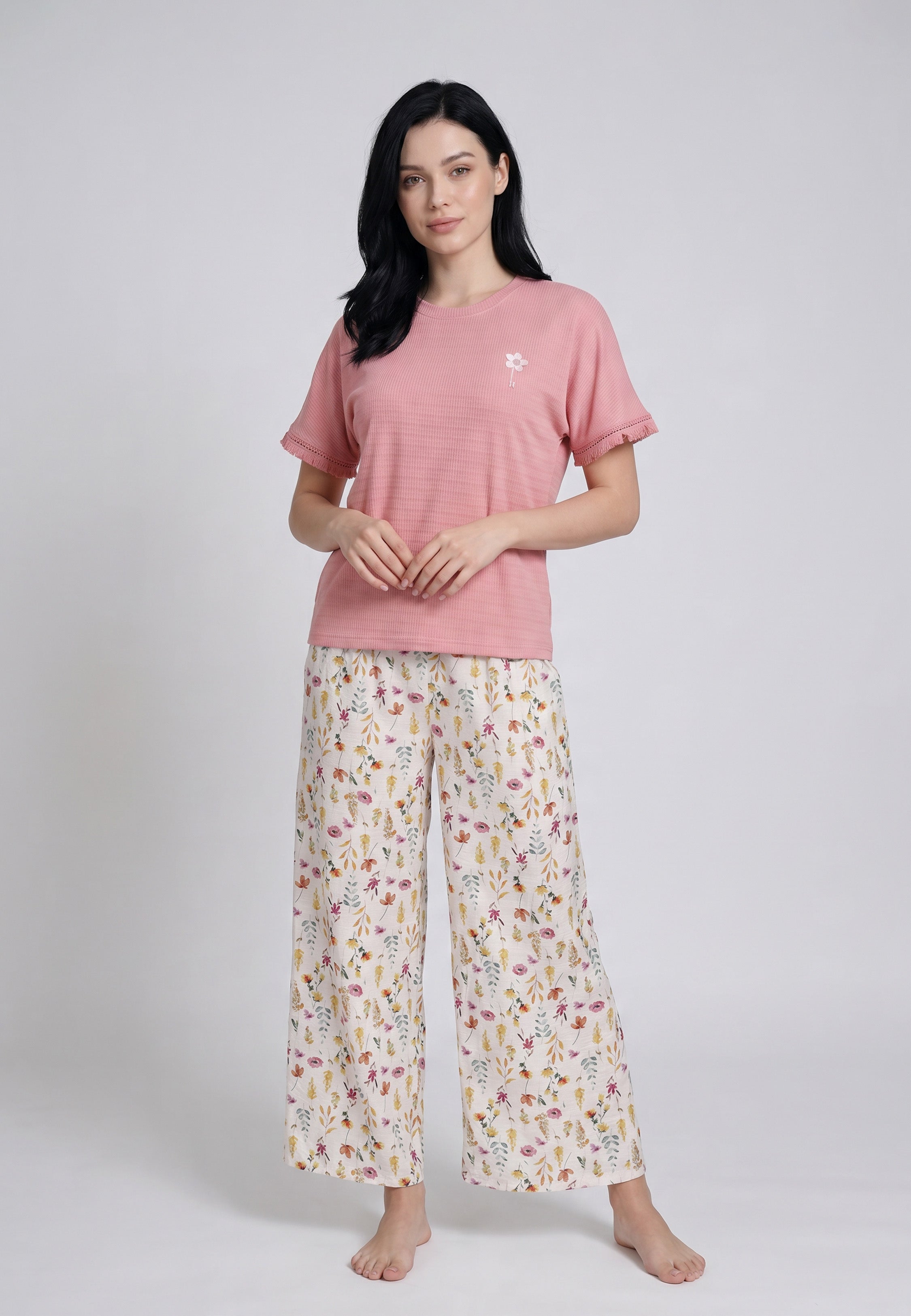 Femme portant un ensemble loungewear top col rond côtelé rose bordure dentelle badge floral et pantacourt large crème imprimé petites fleurs sauvages multicolores Rosabella