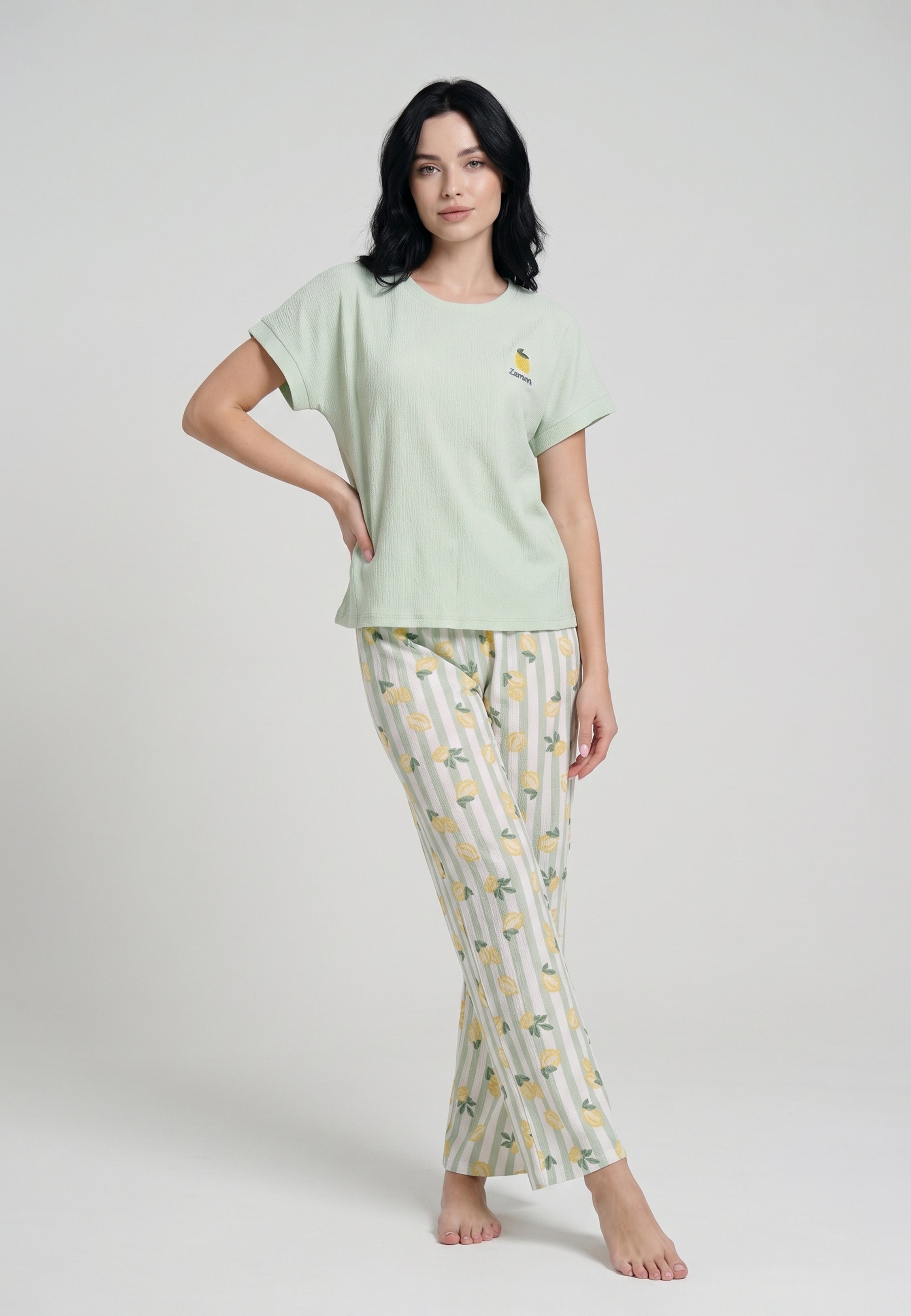 Femme portant un ensemble loungewear top col rond uni vert menthe badge brodé citron et pantalon large rayures vert blanc imprimé citrons jaunes Rosabella