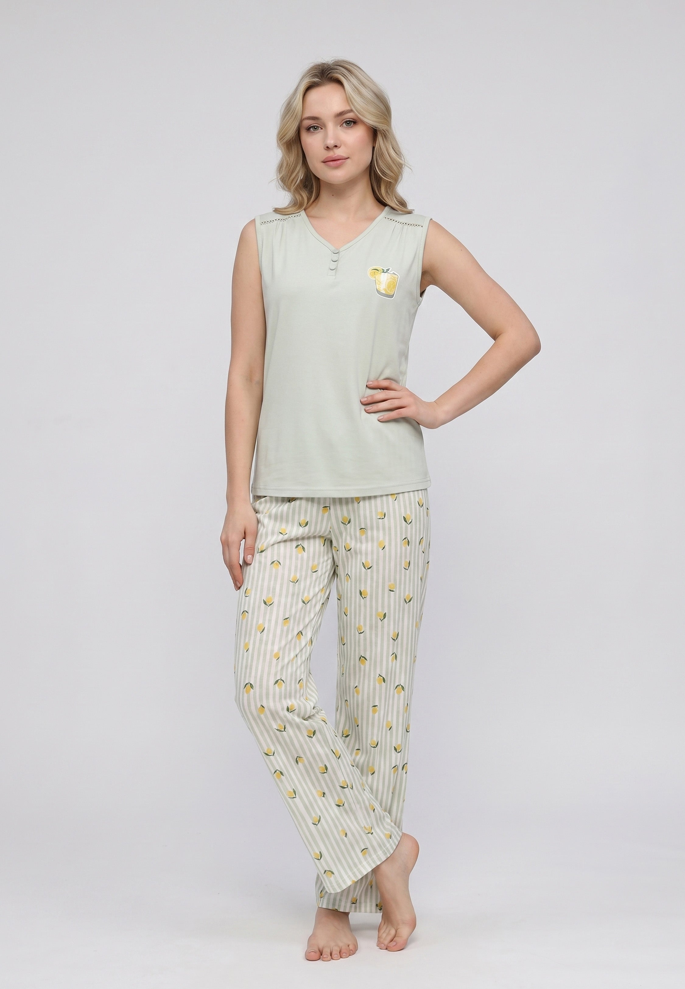 Femme portant un pyjama débardeur sans manches col V boutonné vert sauge badge citronnade et pantalon rayé vert sauge blanc imprimé petits citrons Rosabella
