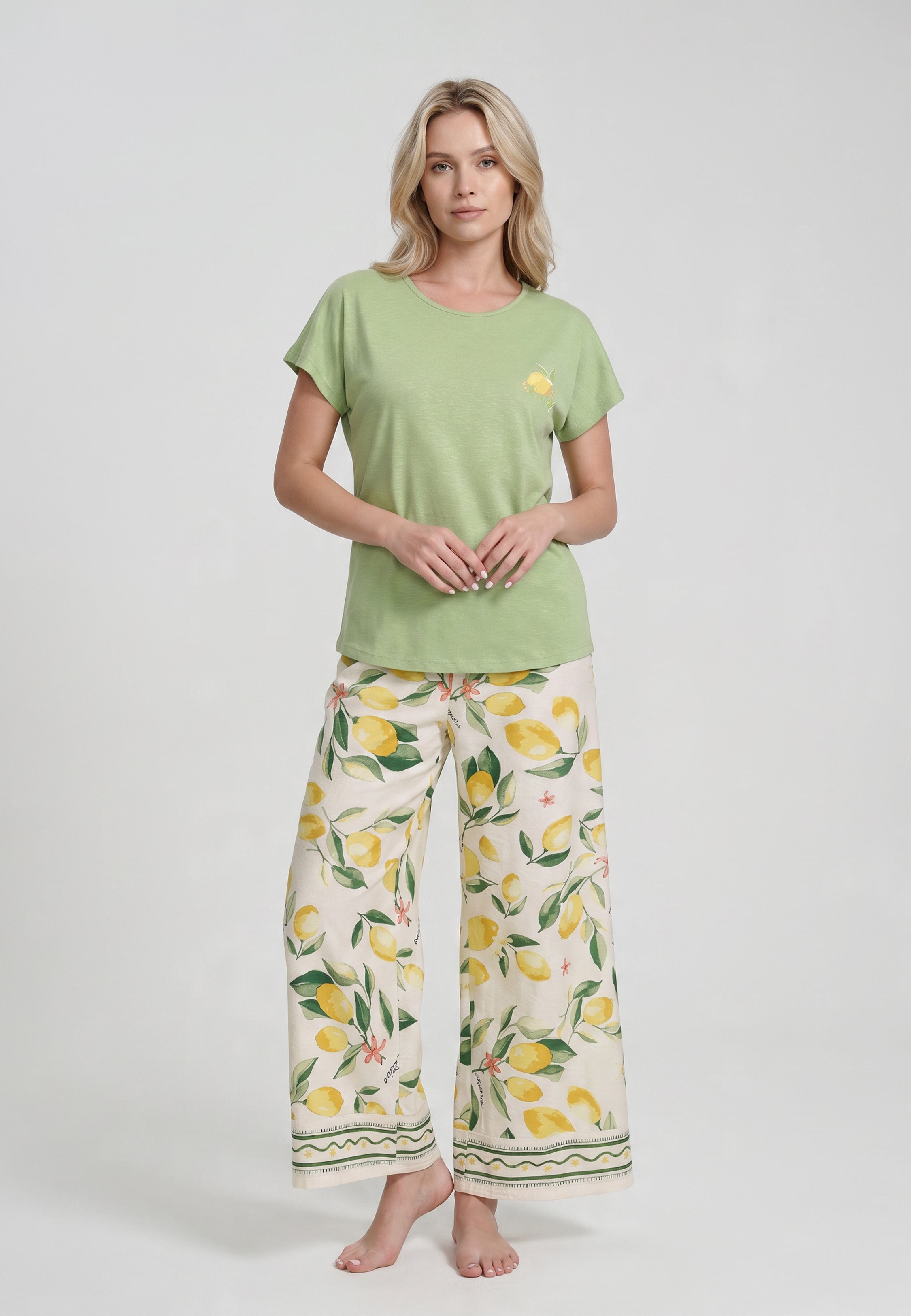 Femme portant un ensemble loungewear t-shirt col rond vert menthe badge citron et pantalon large palazzo crème imprimé grands citrons aquarelle bordure géométrique Rosabella