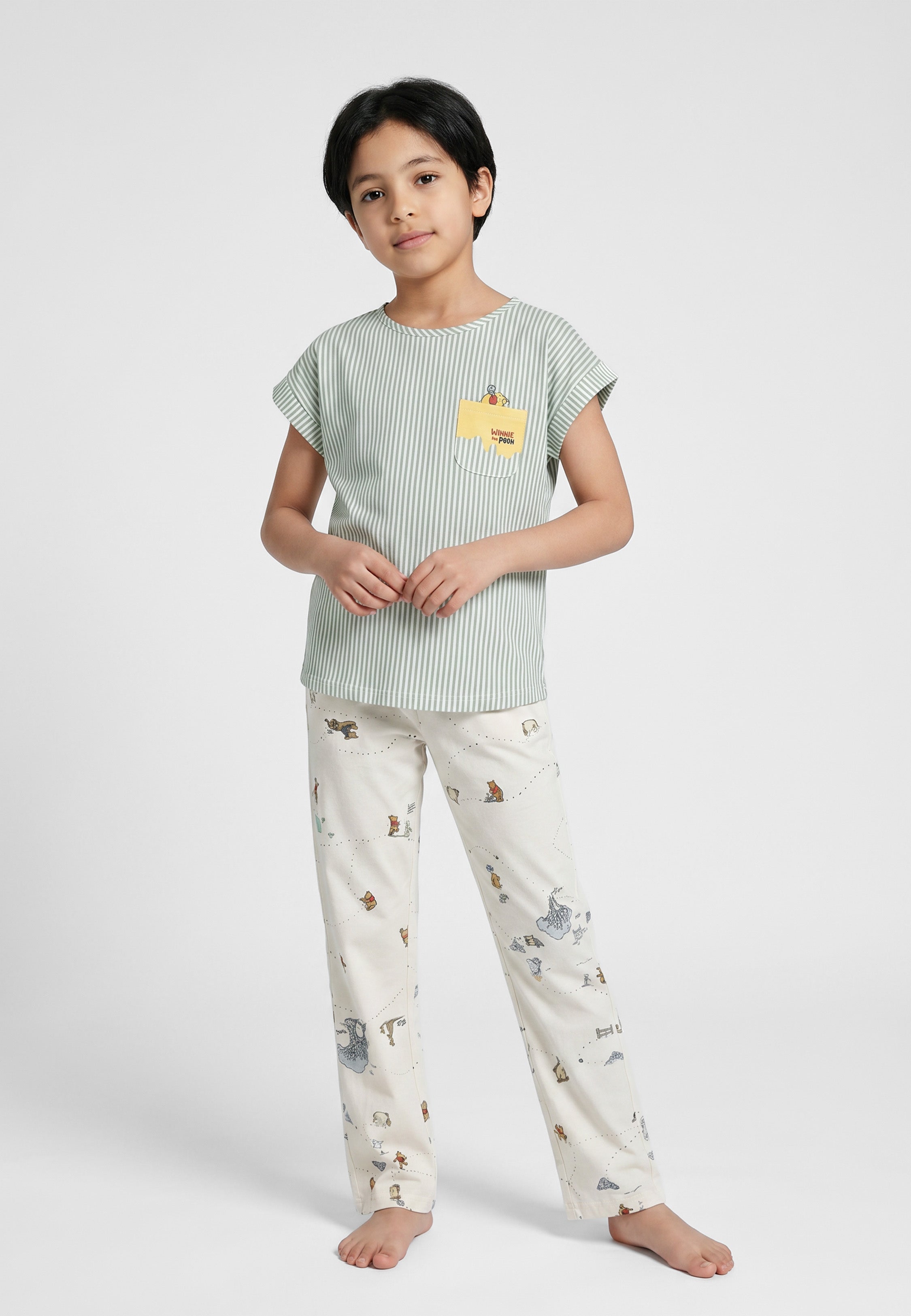 Enfant portant un ensemble pyjama top col rond seersucker rayé vert sauge poche patchée et pantalon imprimé fond crème Rosabella