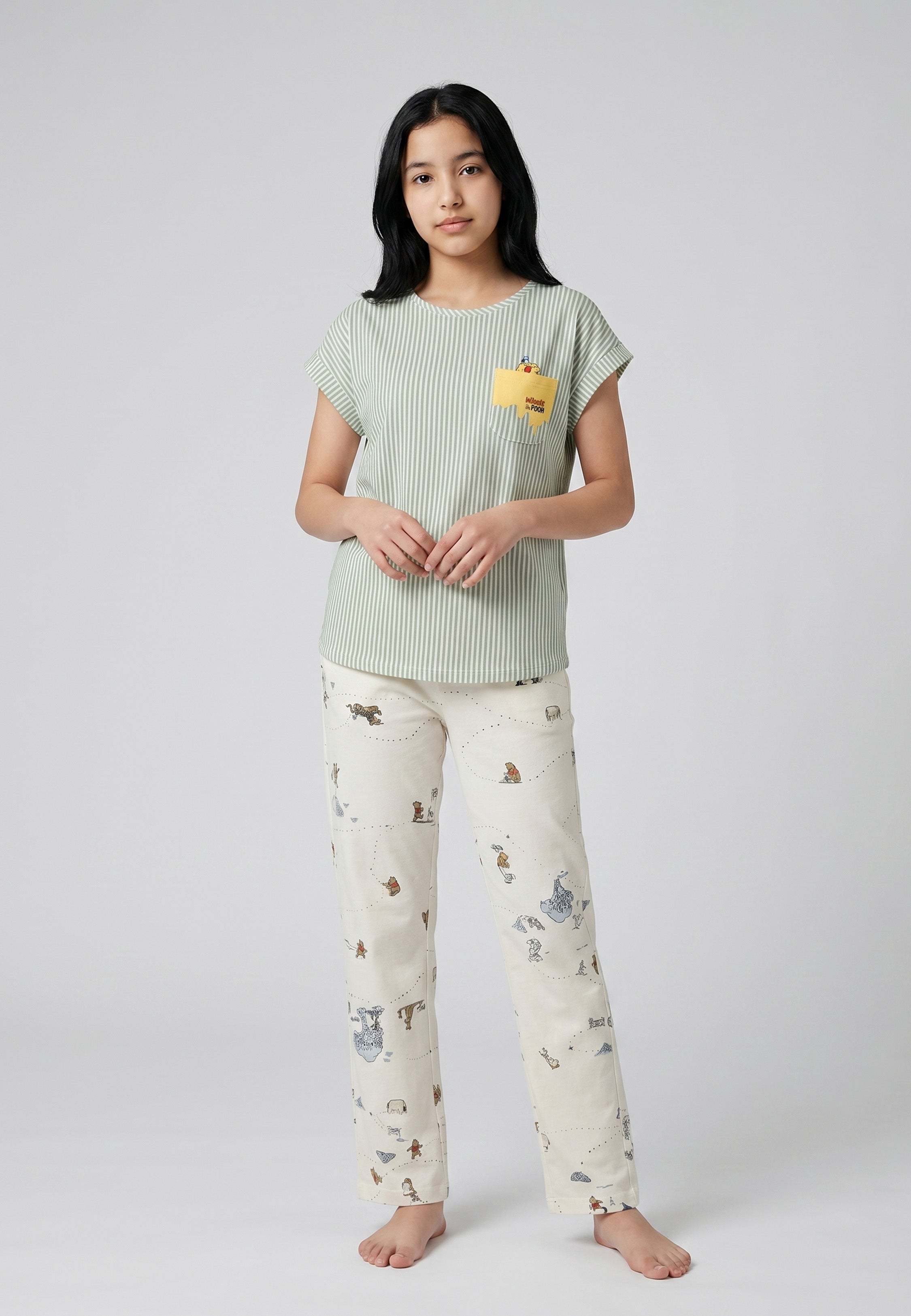 Adolescente portant un ensemble pyjama top col rond seersucker rayé vert sauge poche patchée et pantalon imprimé fond crème Rosabella